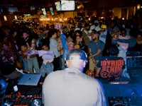 a crowd of people watching a dj